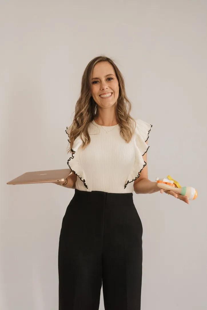 Jackie holding a laptop and a baby toy
