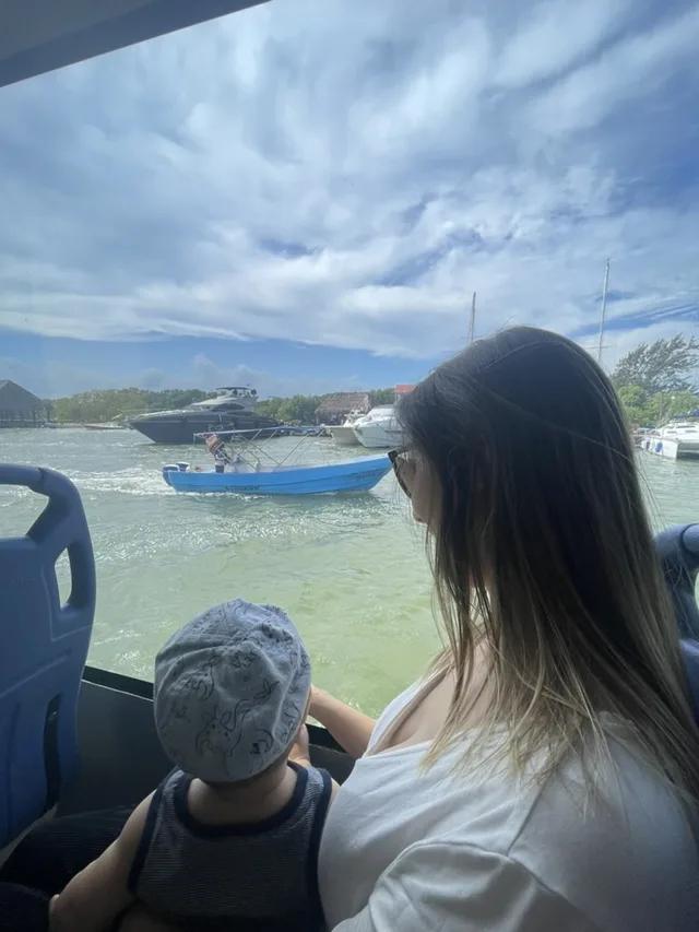 Jackie and her son on a boat, looking out at the water